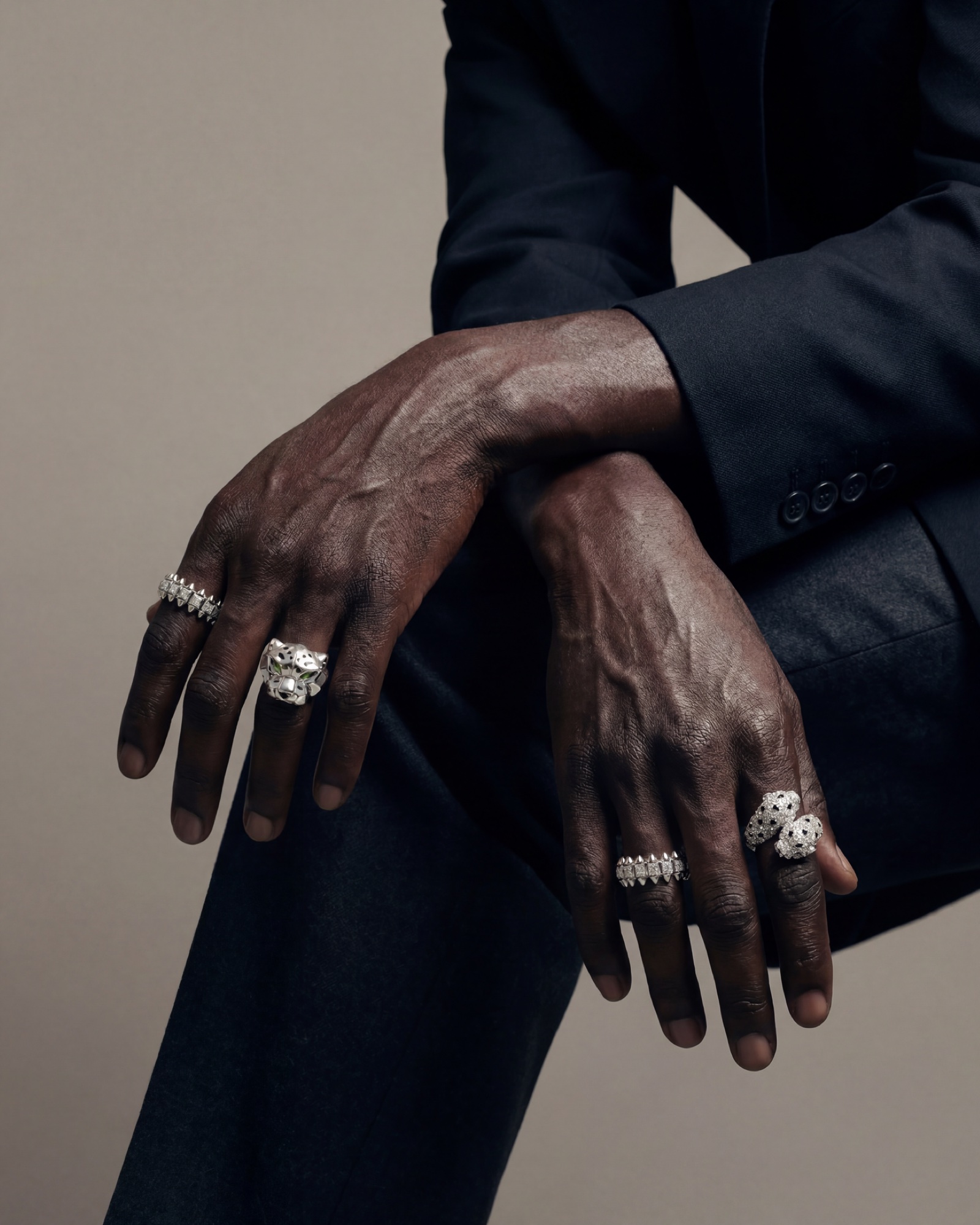 Hands resting over a knee, rings stacked across both