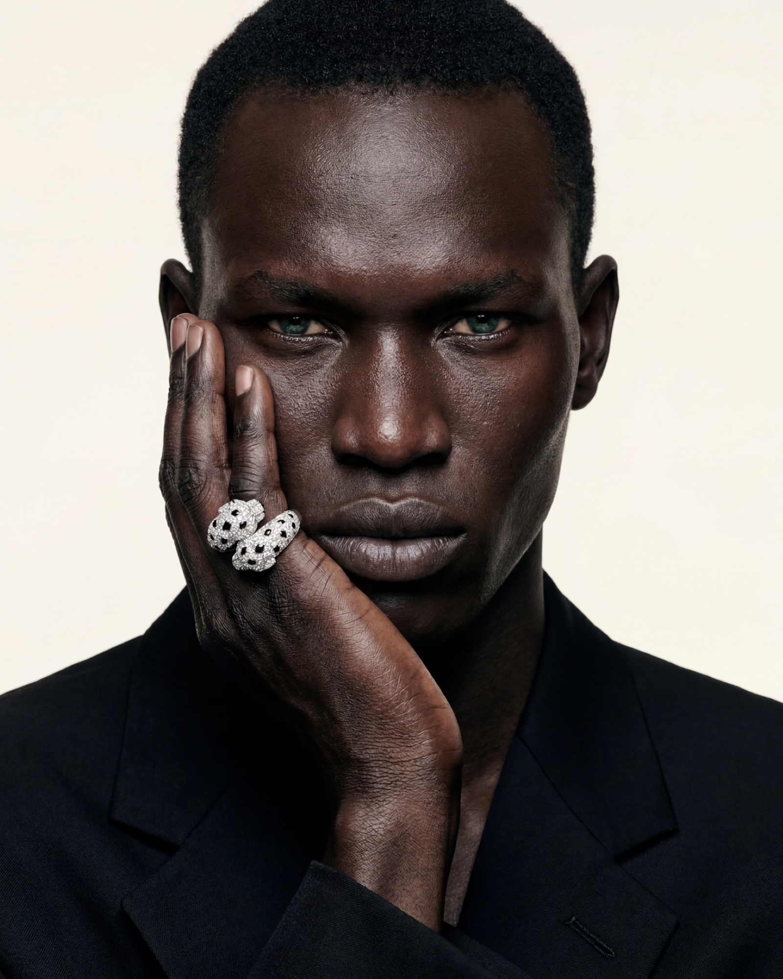 Portrait, hand to the cheek, the model&rsquo;s green eyes matching the panther&rsquo;s