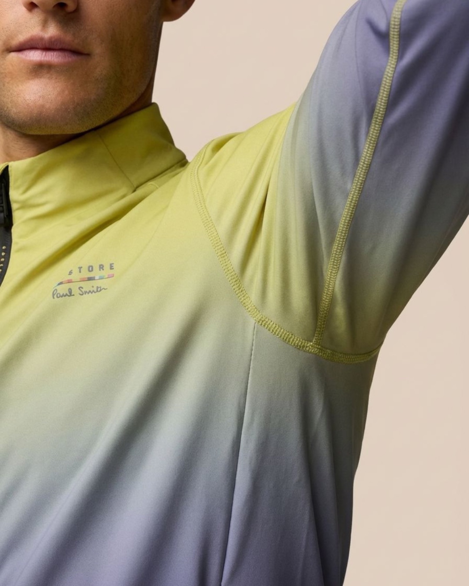 Shoulder detail of the Castore x Paul Smith top showing the panel gradient