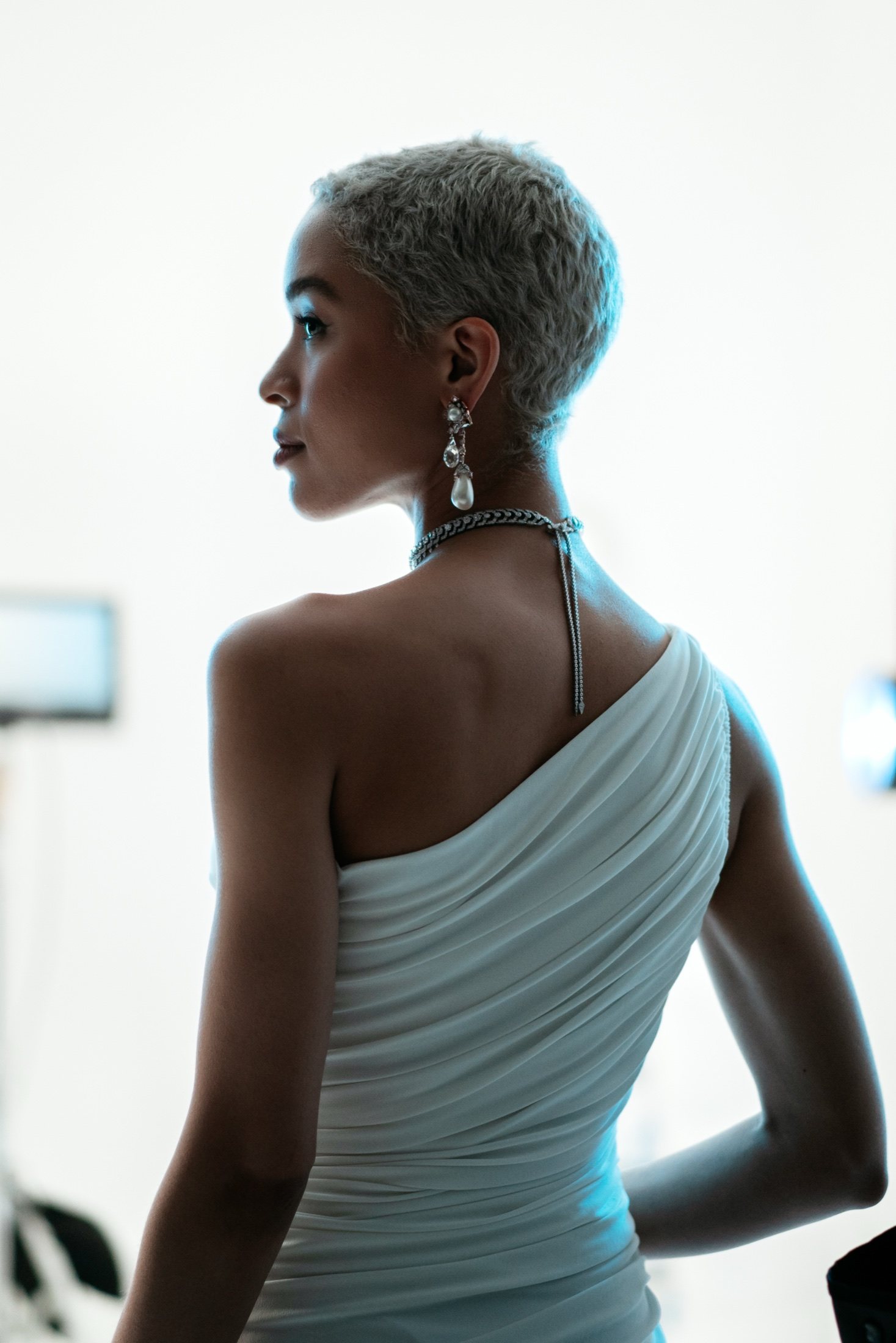 Model in profile, blue-lit, between takes