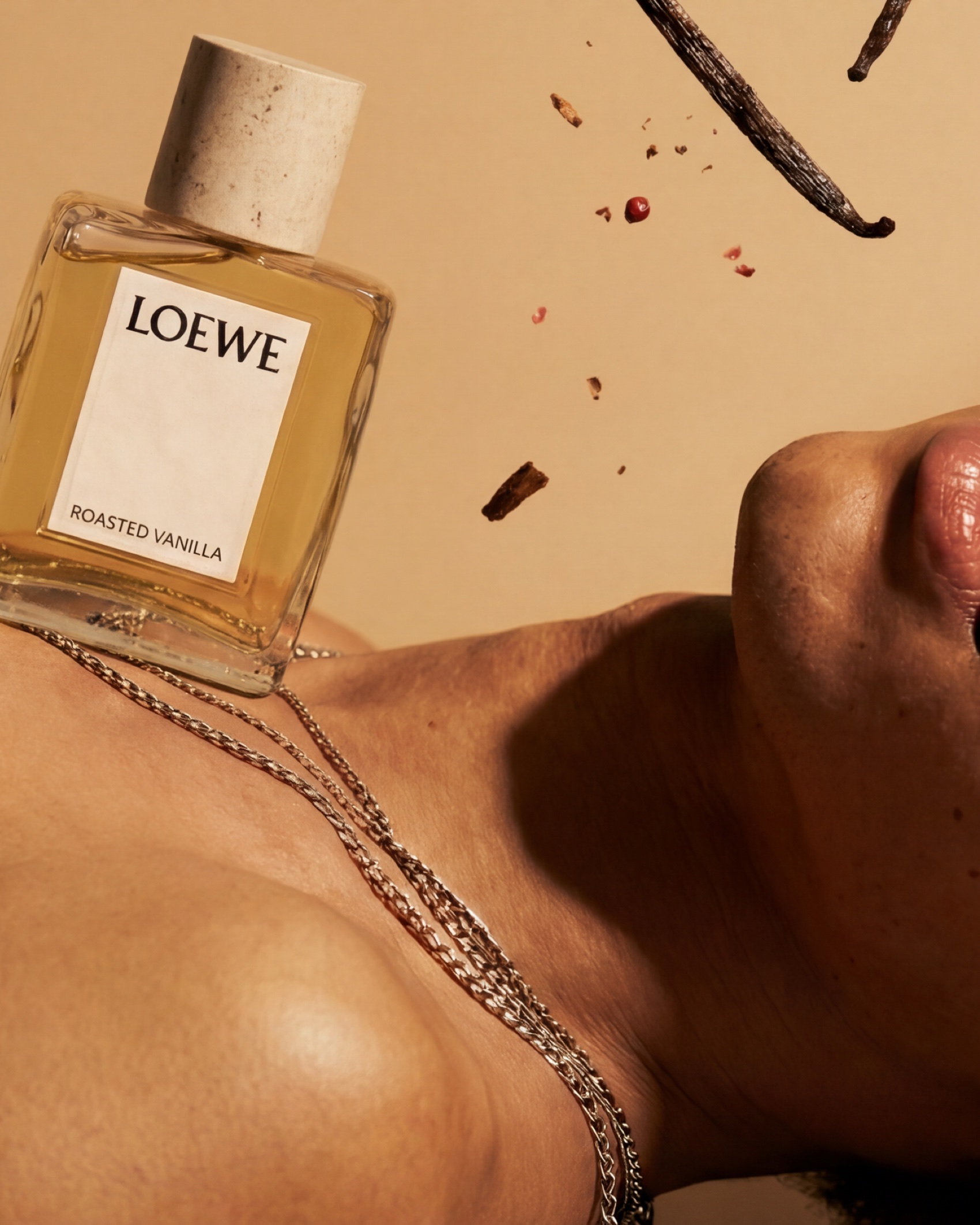 The bottle resting against a chain on skin