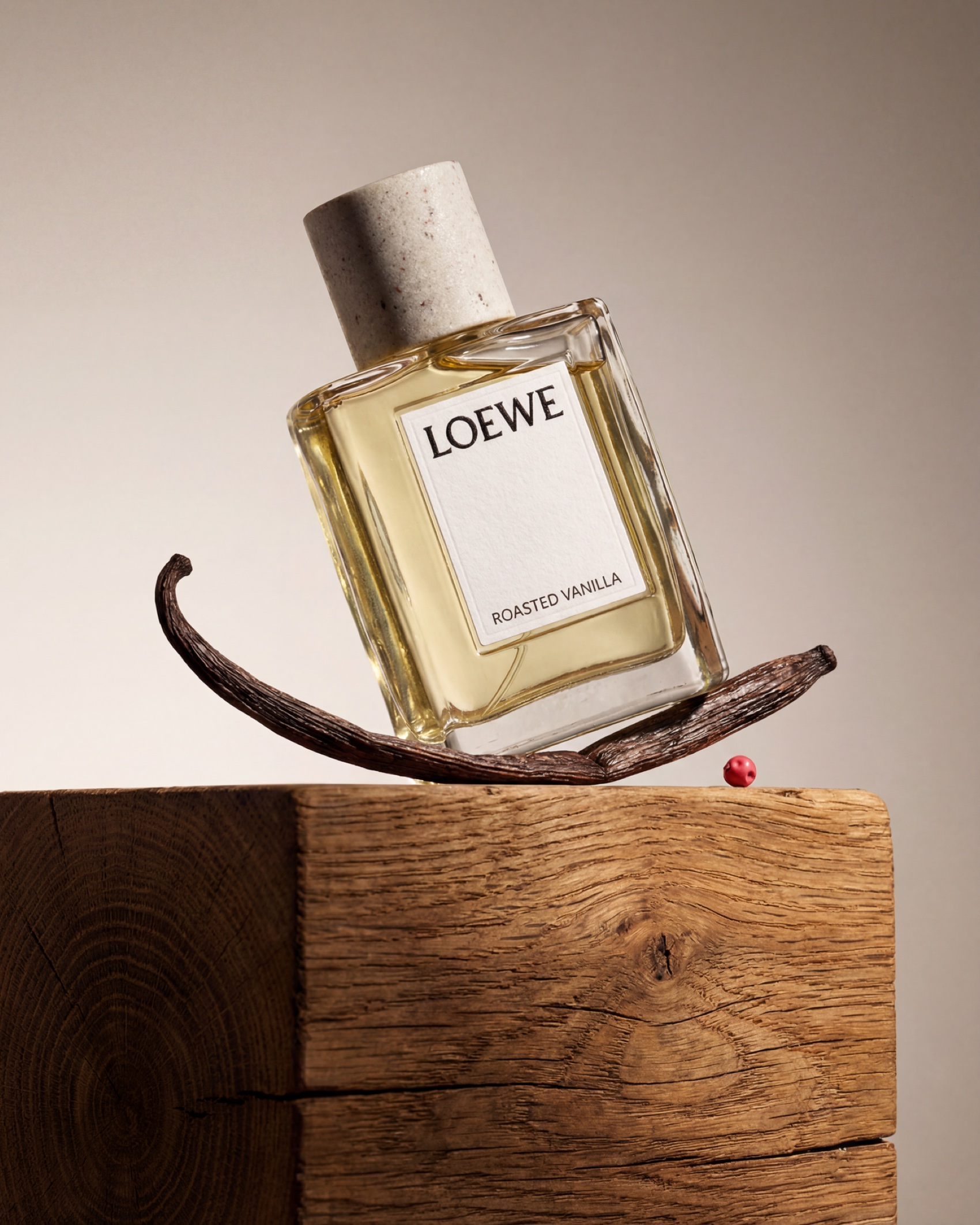 The bottle balanced on an oak block with a vanilla pod