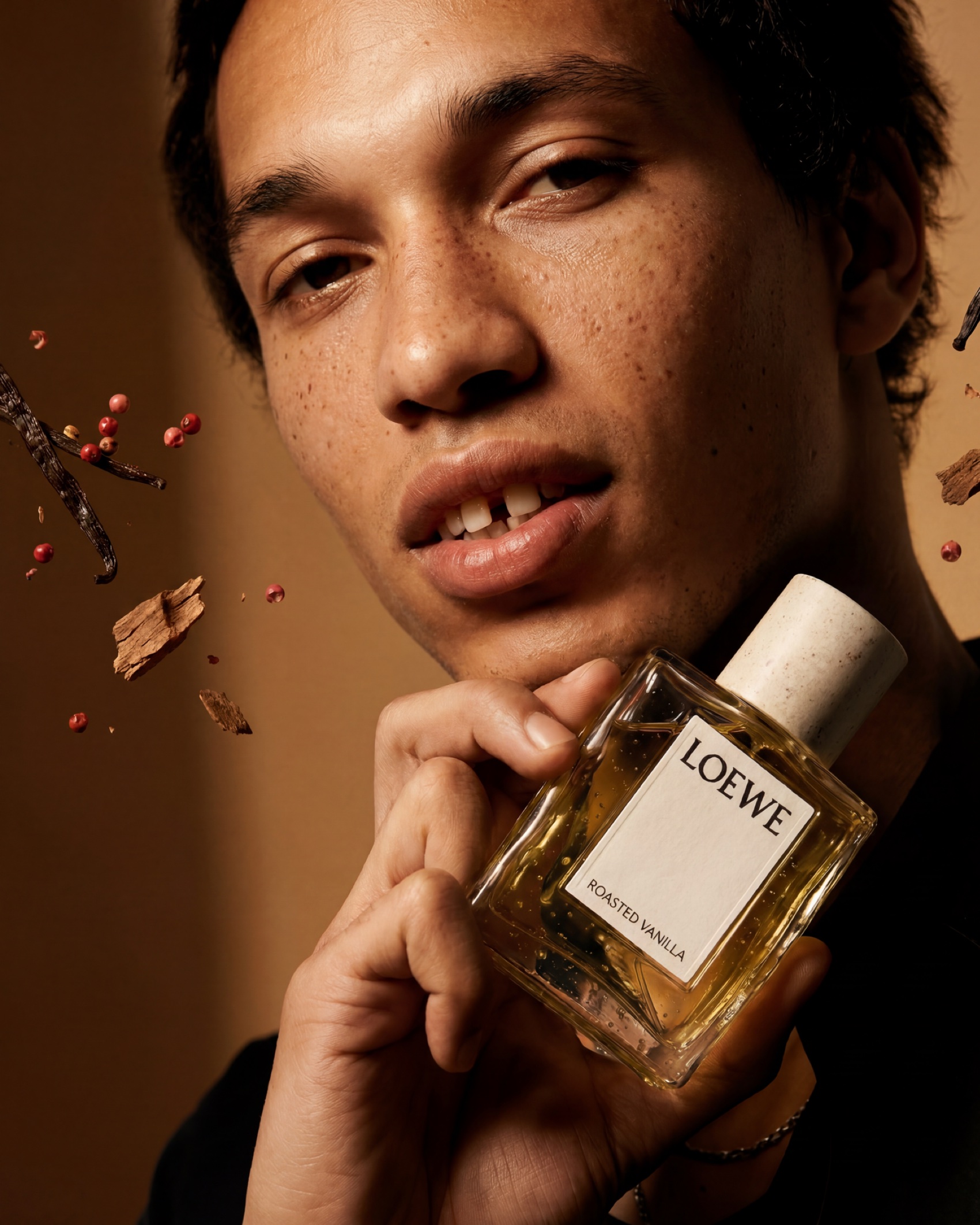 Portrait: the bottle held at the jaw, ingredients suspended around