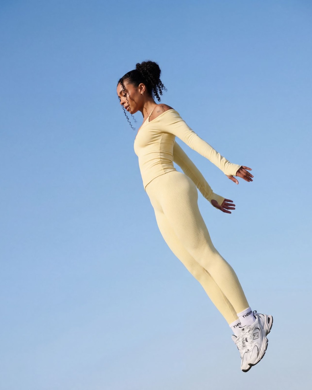 Thrivin campaign frame: a model suspended in profile against blue sky