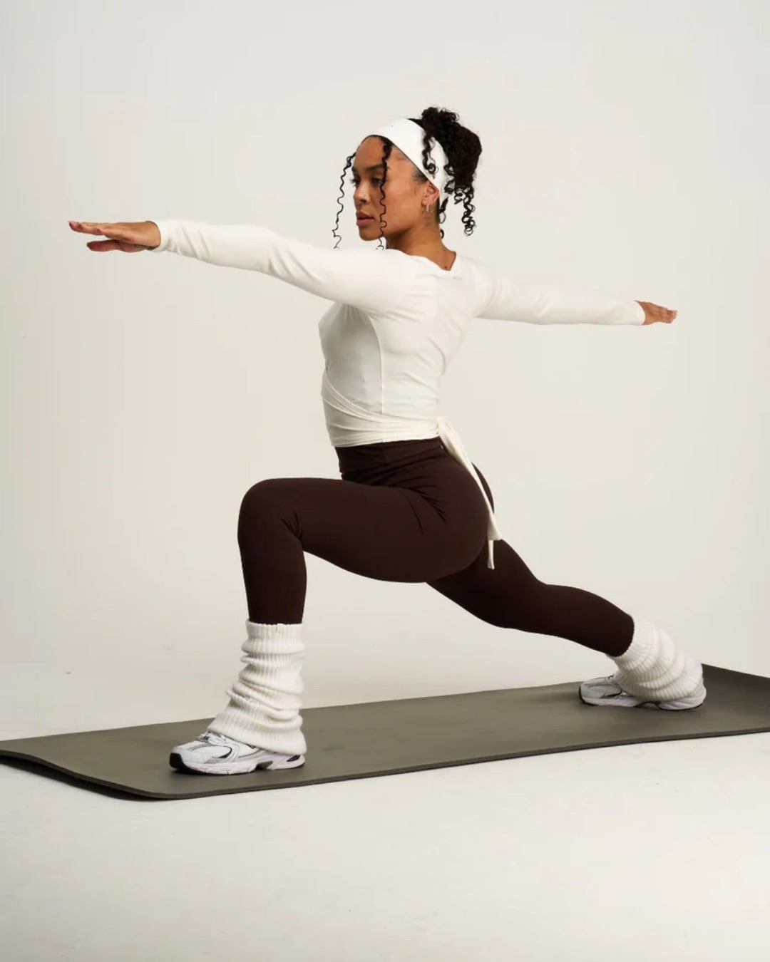 Thrivin studio frame: a full-length training pose on a neutral ground