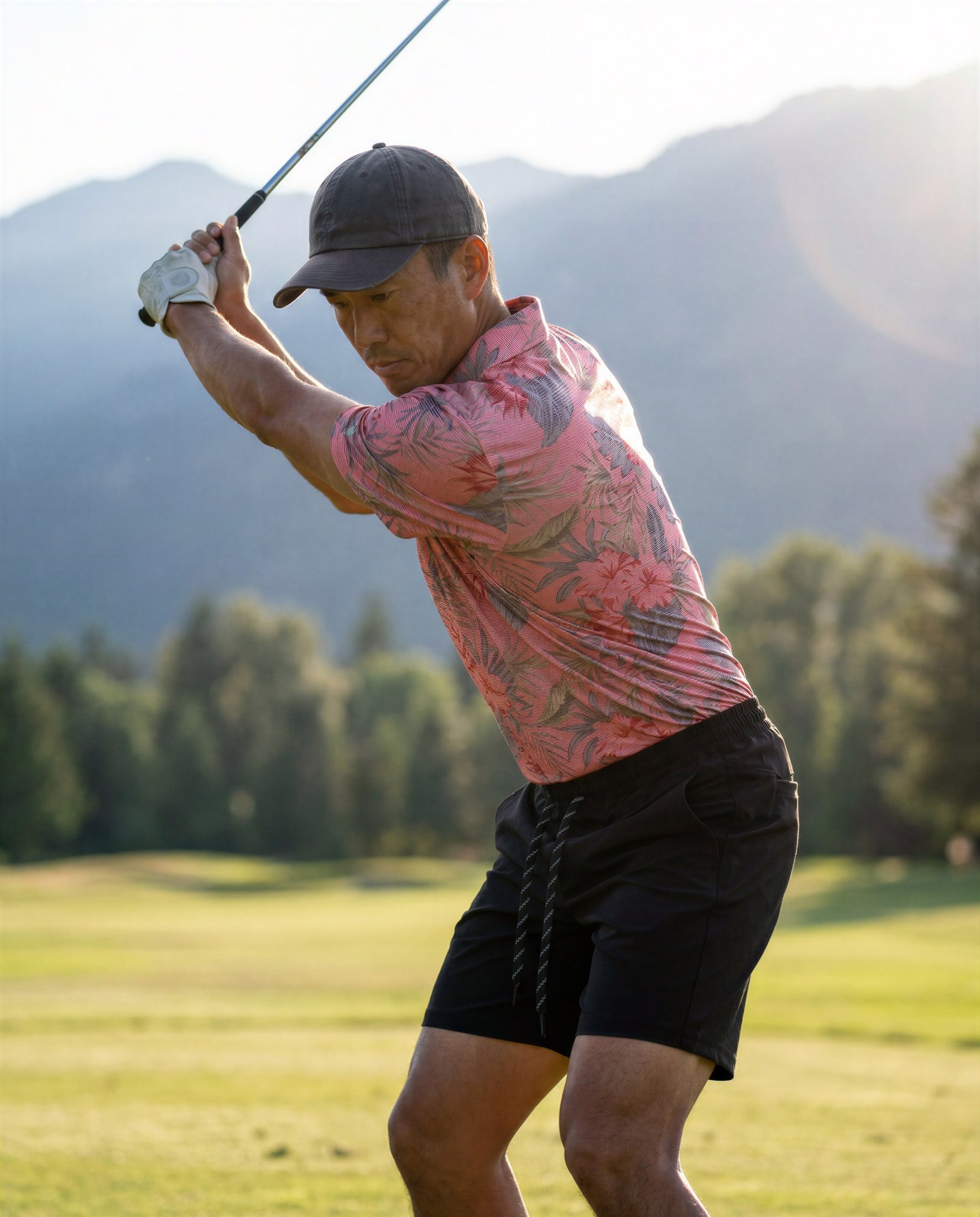 Golfer mid-swing against a mountain backdrop