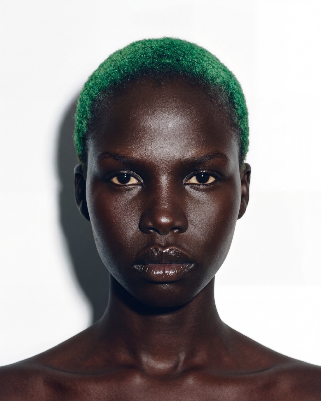 Casting portrait: green buzz cut against a bare ground